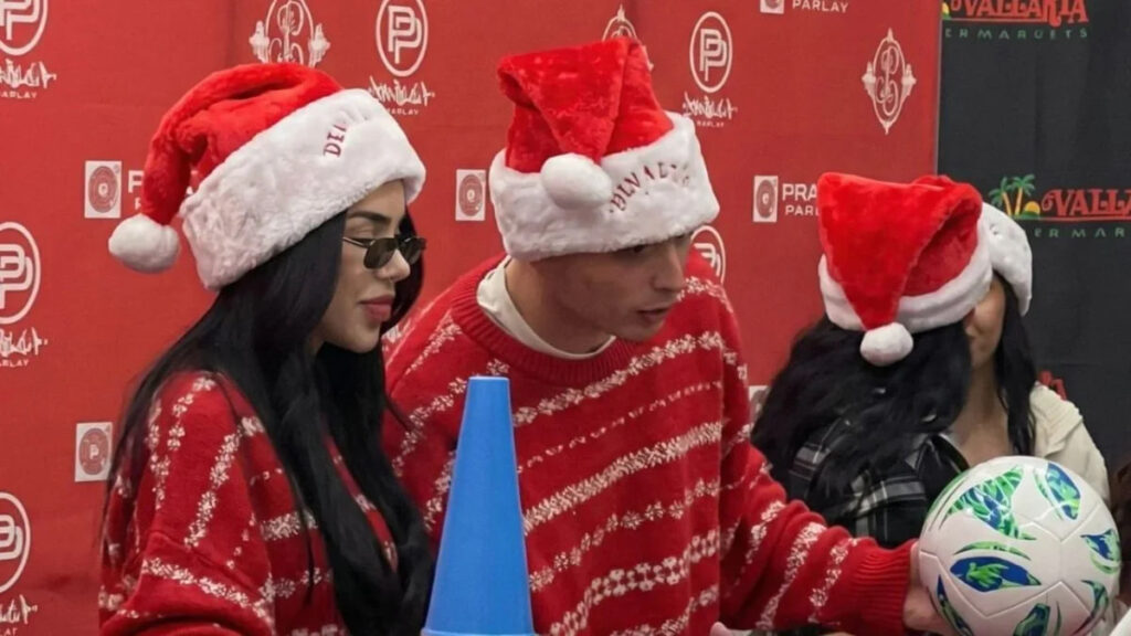 Kenia Os y Peso Pluma durante una entrega de juguetes a familias latinas en Los Ángeles, en un evento comunitario navideño.