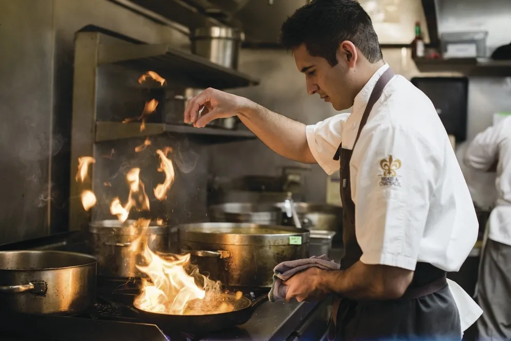 Chef latino preparando platillo moderno en restaurante de alta cocina representando a los chefs latinos 2025 con reconocimiento internacional.