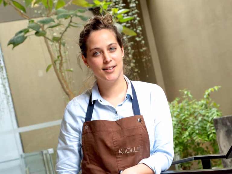 Retrato de Pía León preparando un plato creativo en la cocina de Kjolle, con enfoque en gastronomía latinoamericana.