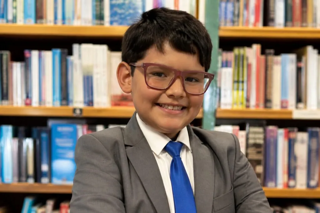 niño genio latino con coeficiente intelectual superior al de Einstein en entorno educativo moderno