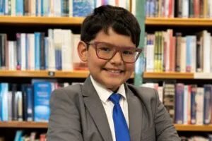 niño genio latino con coeficiente intelectual superior al de Einstein en entorno educativo moderno
