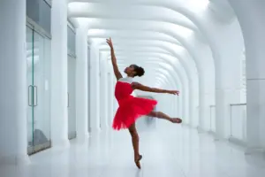 Bailarina latina ejecutando una presentación de ballet en un escenario internacional