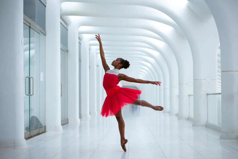 Bailarina latina ejecutando una presentación de ballet en un escenario internacional